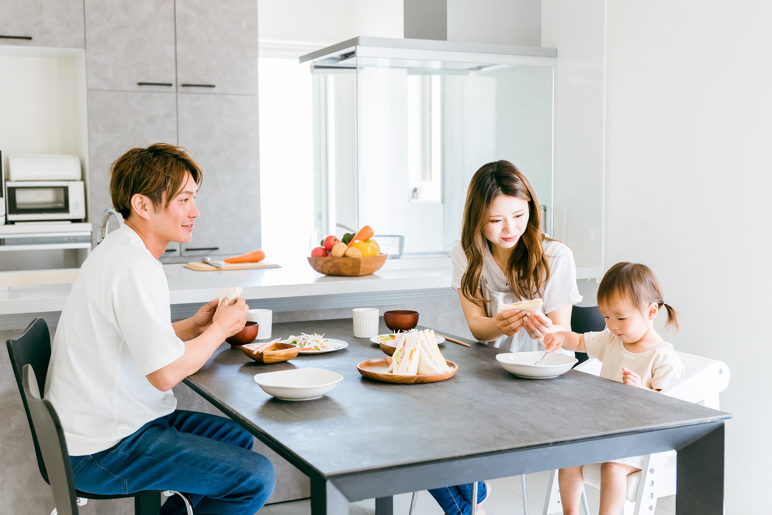 明るいダイニングで家族が食事を楽しむ様子